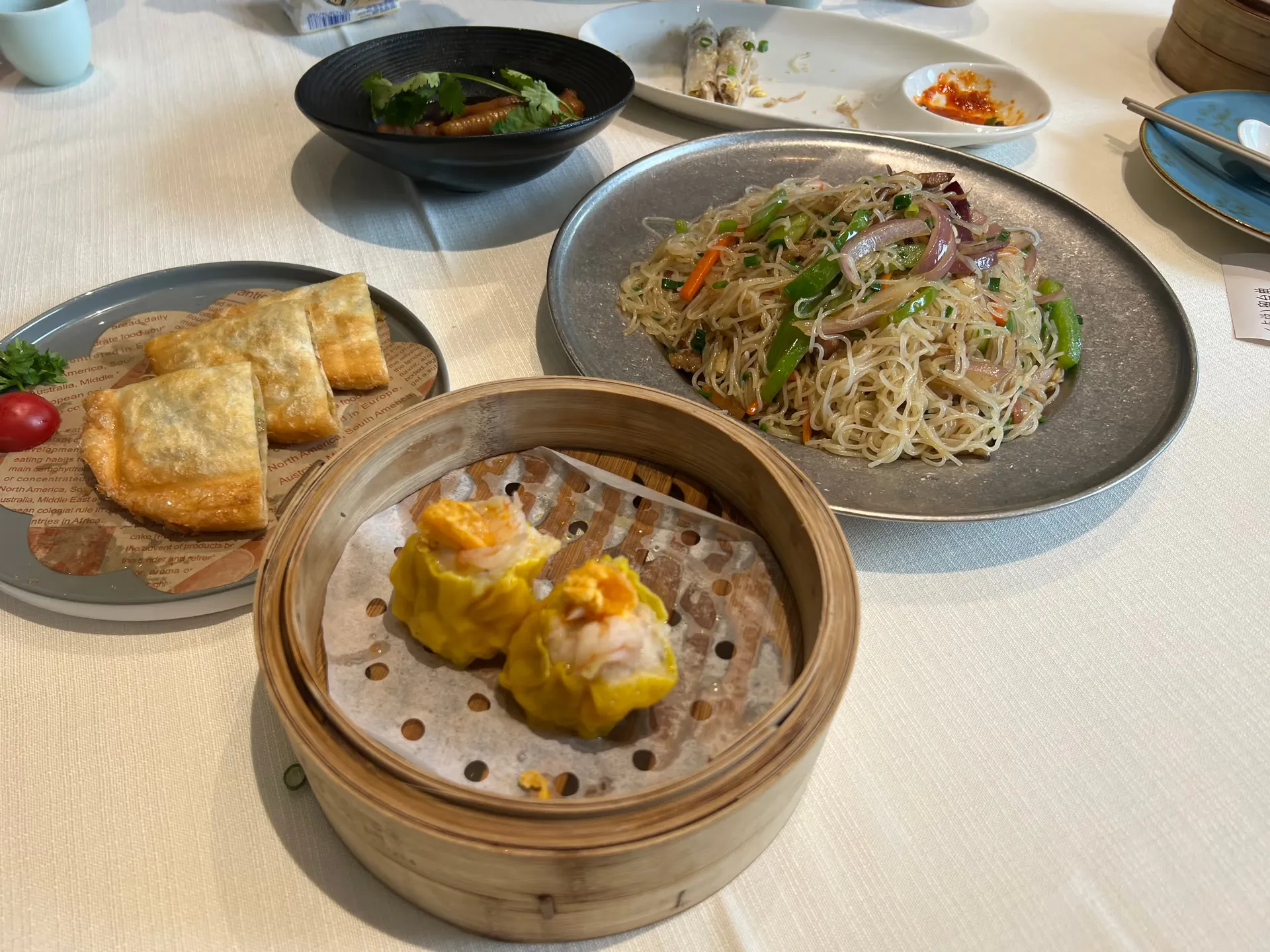 A table of dim sum and fried noodles