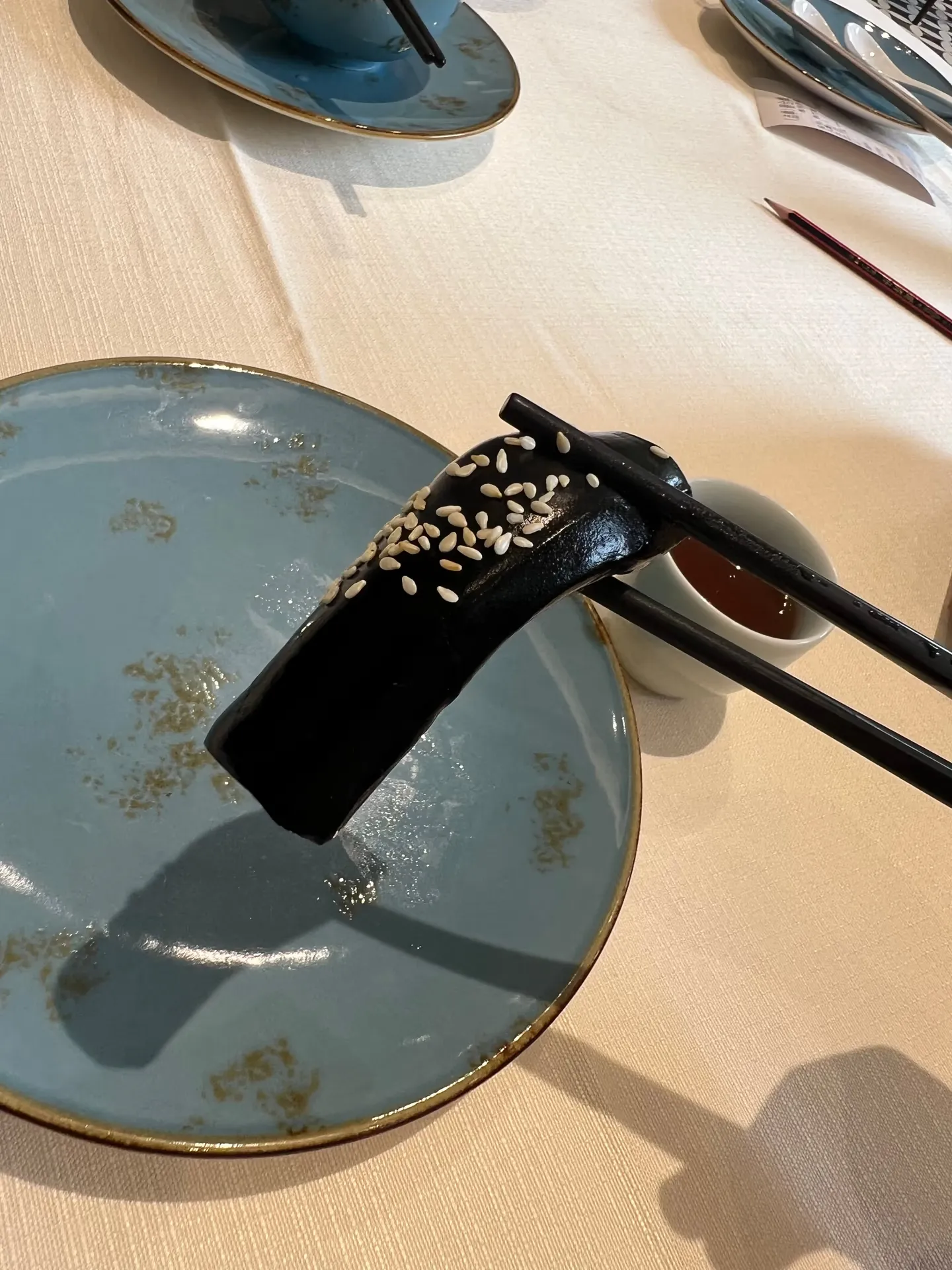 A chewy black cake held in chopsticks