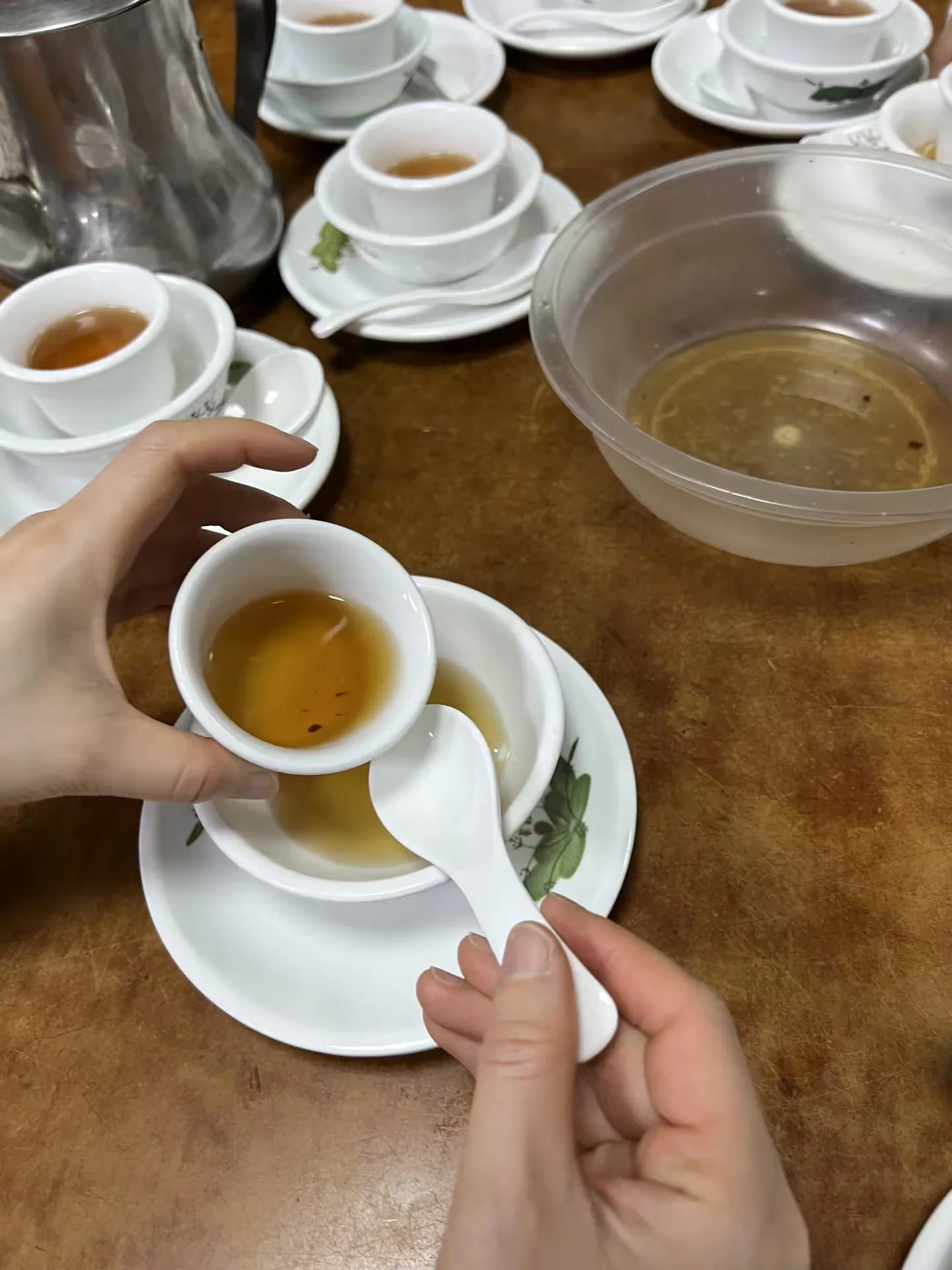 Rinsing the dishes with the first pour of tea and a pair of small tongs