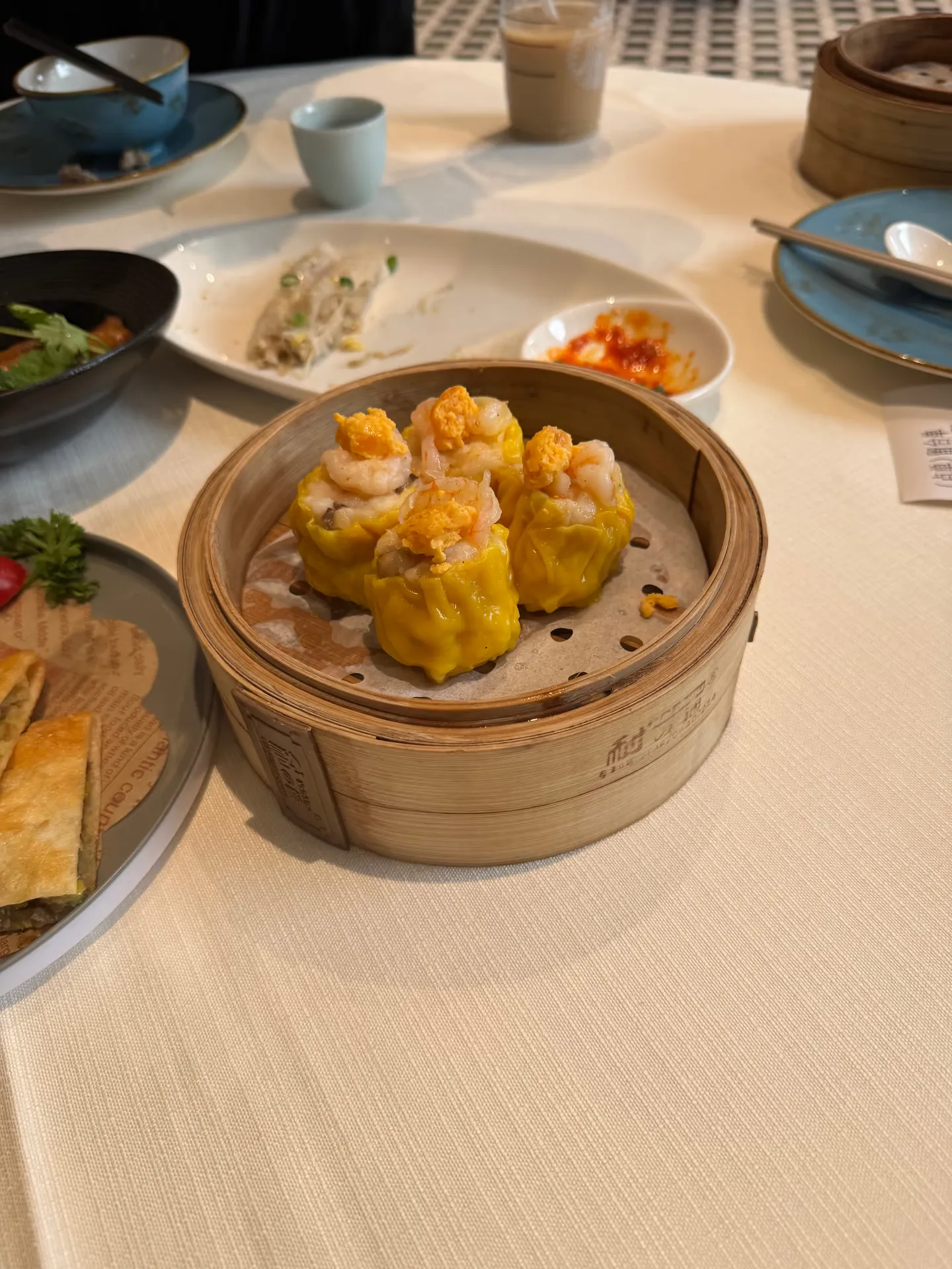 Yellow siu mai in a bamboo steamer